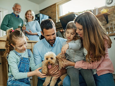 young-parents-and-their-small-daughter-enjoying-with-dog-at-home-grandparents-are-standing