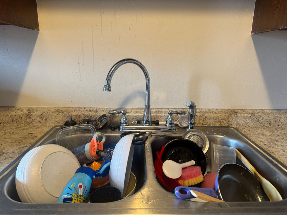 pile of dishes in sink