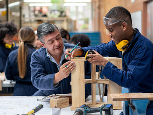 Industrial design student building furniture with the help of his teacher
