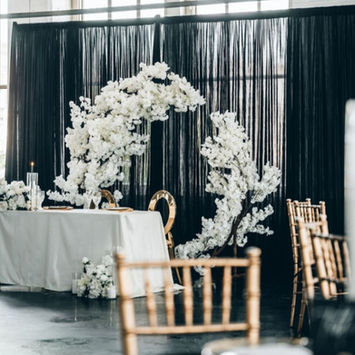 Wedding ceremony decorated with white flowers, table, and chairs for event.