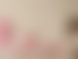 Pregnant woman standing next to a large pink ribbon, symbolizing breast health awareness and mammology during pregnancy.