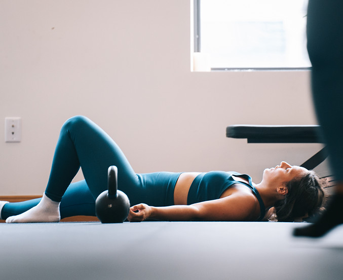 Woman resting on floor at Ekstasis Movement Studio