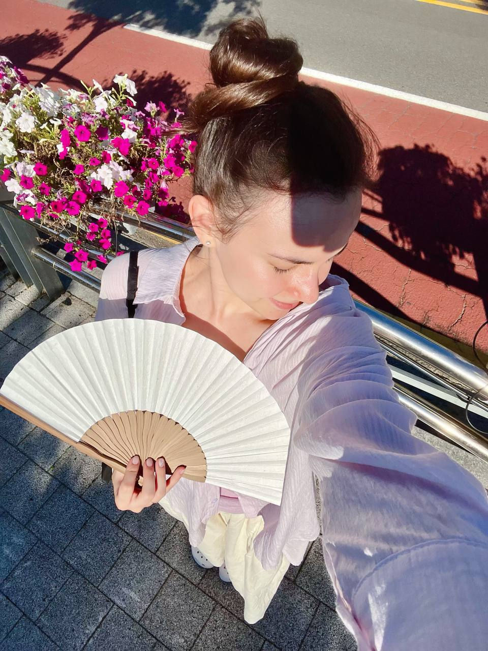 I'm standing with a fan in Yangyang, near the road