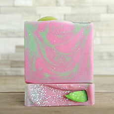 Two bars of grapefruit lime scented artisan soap. Swirls of bright pink and lime, topped with biodegradable holographic glitter and a soap lime embed.