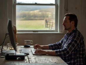 A man working on a computer in a rustic home office environment