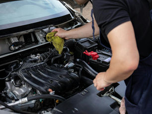 Close-up of mechanic repairing a car engine, focusing on maintenance and cleaning.