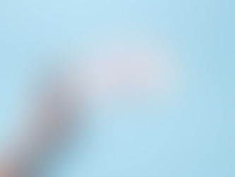 A hand reaching out to a stack of CDs on a blue backdrop, evoking nostalgia for retro technology.