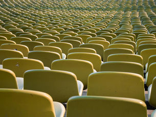 Rows of empty yellow seats in a stadium in Munich, Germany, emphasizing repetition and symmetry.
