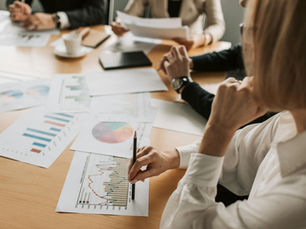 Business professionals reviewing charts and graphs during a meeting in office setting.