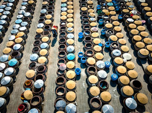 Aerial shot showcasing rows of traditional fermentation jars in a Chinese setting.