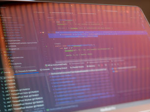 Focused view of a computer screen displaying programming code with visible reflections.
