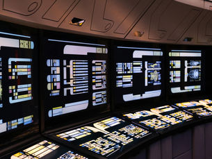 A high-tech command center with illuminated digital screens in a futuristic setting.