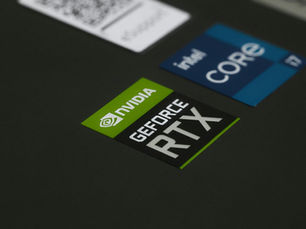 Close-up of NVIDIA GeForce RTX and Intel Core i7 stickers on a laptop surface, showcasing modern technology.