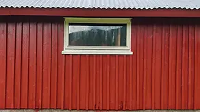 Værslitt låvefasade fotografert før vurdering av overflate og vedlikeholdsbehov