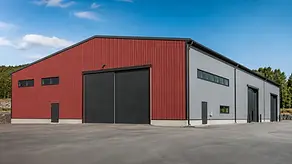Moderne lagerbygg med rød og grå metallfasade, store porter og asfaltområde