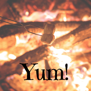 Cooking s'mores over fire in fire pit.