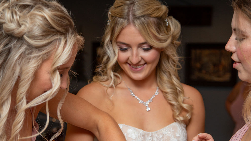 Brides maids putting on a bracelet on the bride