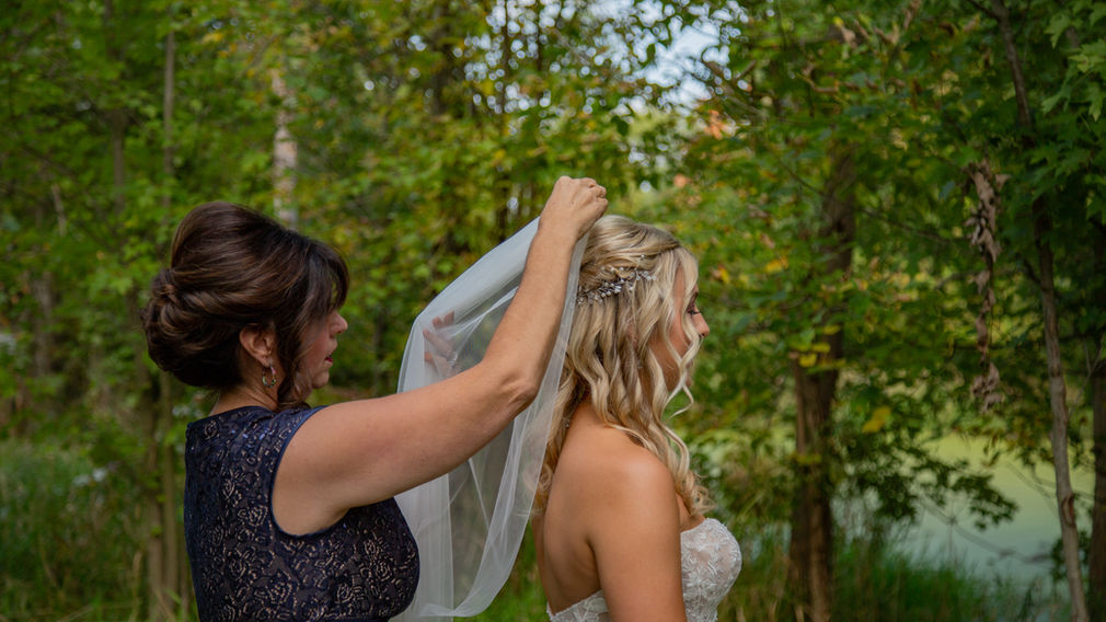 Bride's mother putting veil on