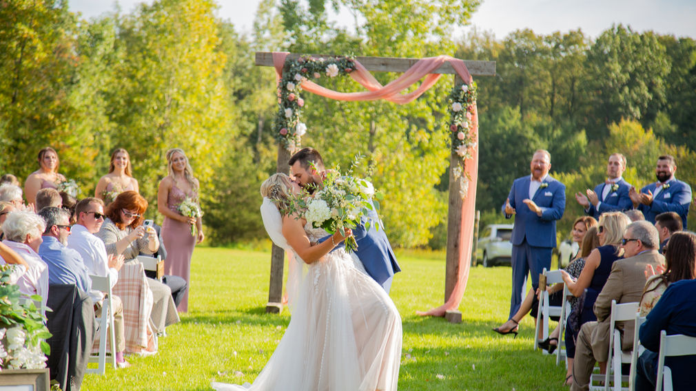 Bride and groom kiss in isle