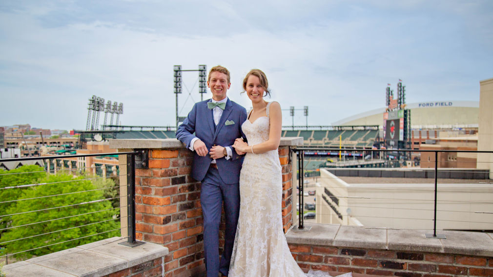 Meghan and Brandan with Comerica Park behind them for the rooftop reception at the Madison in Detroit