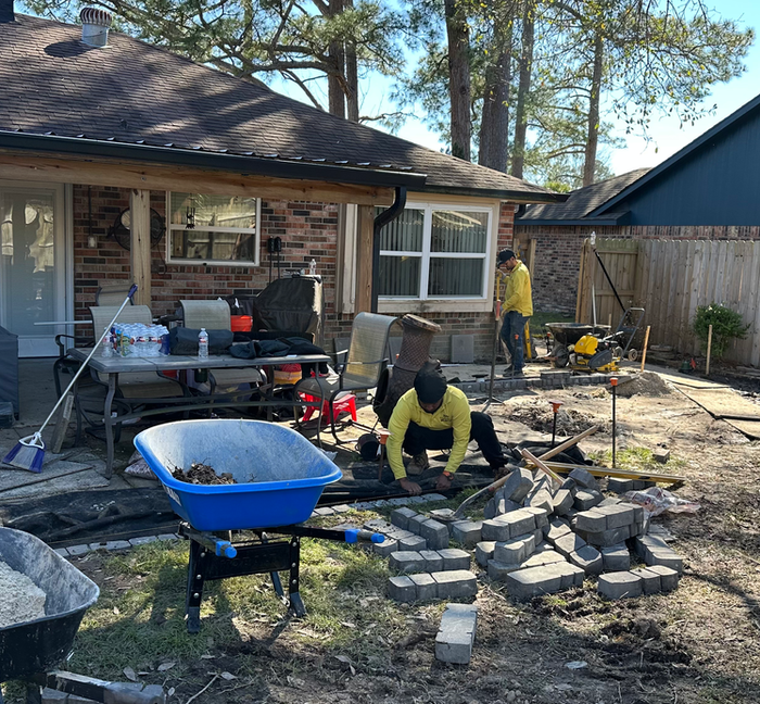 the team installing brick edging around the gravel near the patio