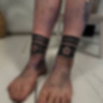 Jade Wildman tattoo of bold blackwork Celtic tribal bands symmetrically placed around ankle