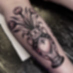 Jade Wildman tattoo bold blackwork traditional vase with tulips on calf female