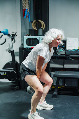 Woman does a squat in a gym setting for fitness and exercise