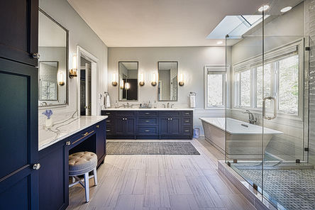 Custom navy blue master bathroom vanities with a glass shower enclosure in NC.