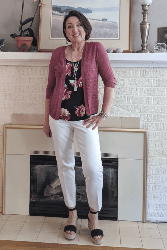 White work pant outfit with a soft rose colored cardigan and navy wedge sandals.