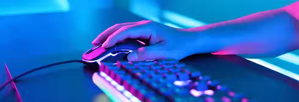 A brightly lit mouse and keyboard for a desktop computer, sitting on a table