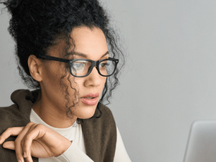 A woman looks at a computer screen while taking a virtual course