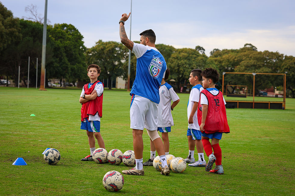 Coach Nick instructs young players on the importance of game intelligence during a football practice session.