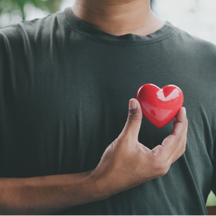 Man holding a red plastic heart to his chest