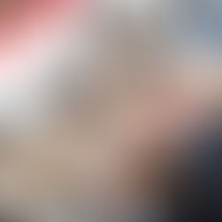 Person in a blue suit typing at a desk while viewing a computer screen displaying a monthly schedule calendar, with office items including a coffee mug, papers, calculator, keyboard, and mouse nearby.