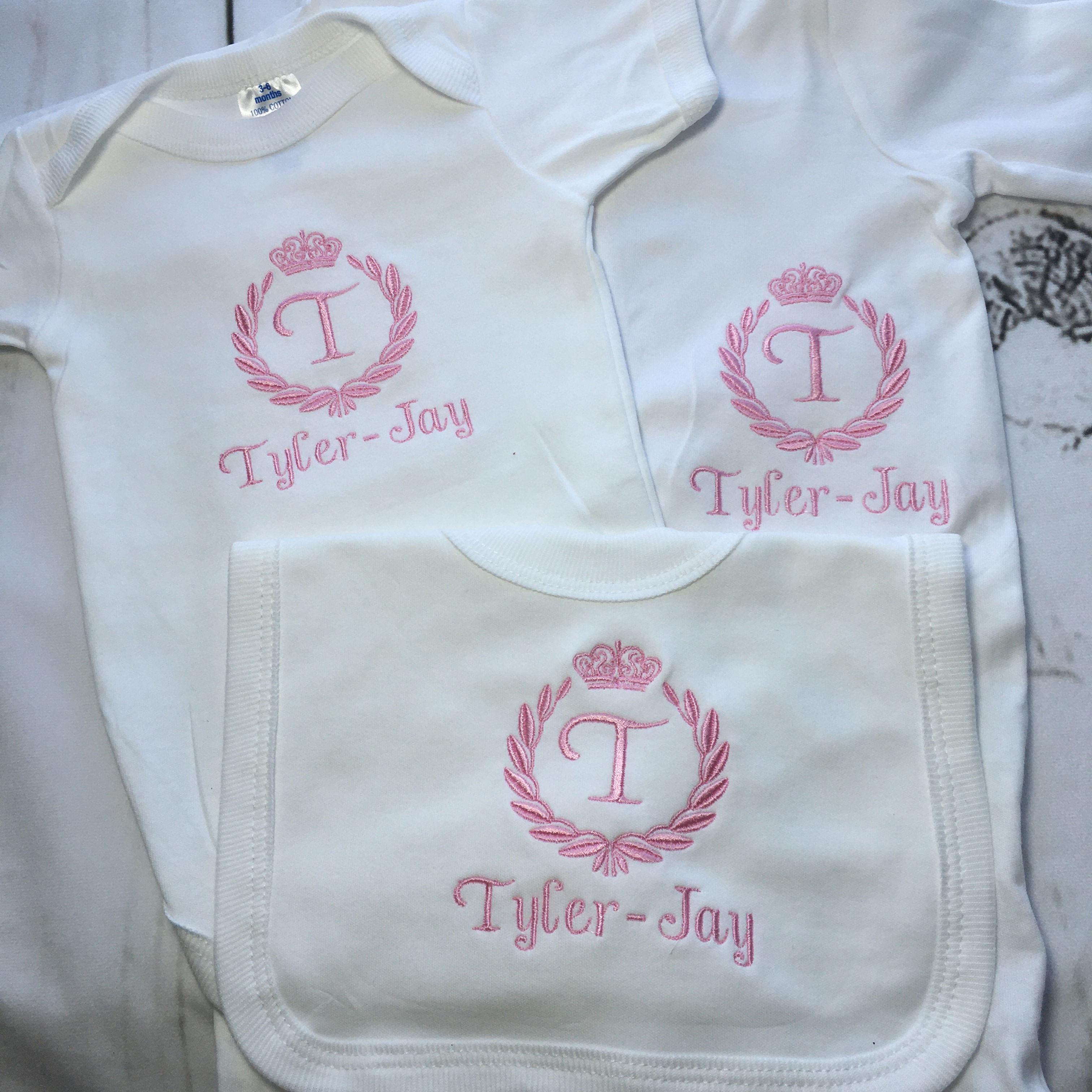 Crown crest sleep suit, bib and vest.