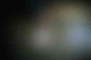 two feet with white socks and two white shoes on the floor