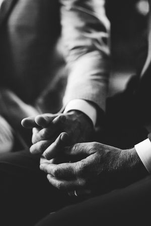 two men holding hands during their wedding ceremony