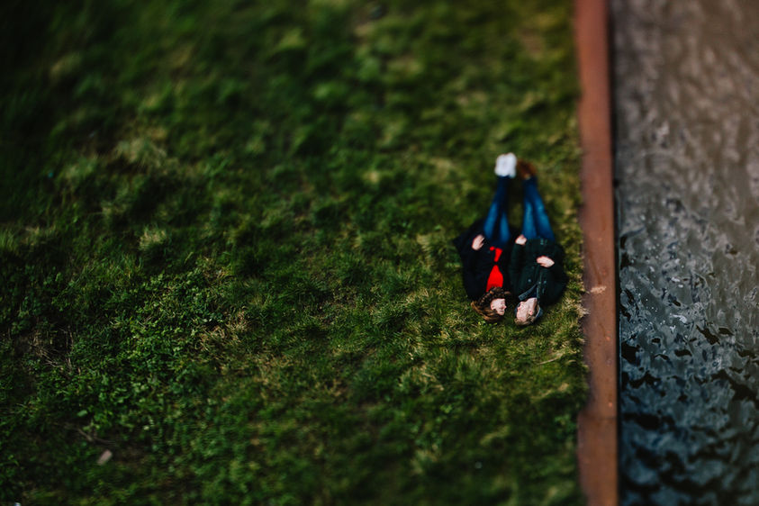 a bird's eye view of couple laying on the grass next to each other