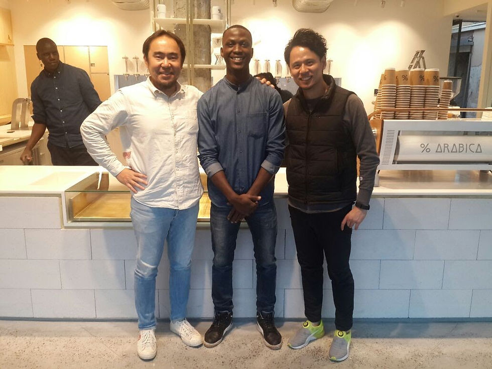 3 men take a photo inside a coffee shop