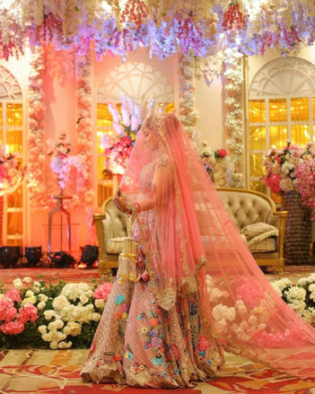 Bride in pink lehenga at decorated wedding venue