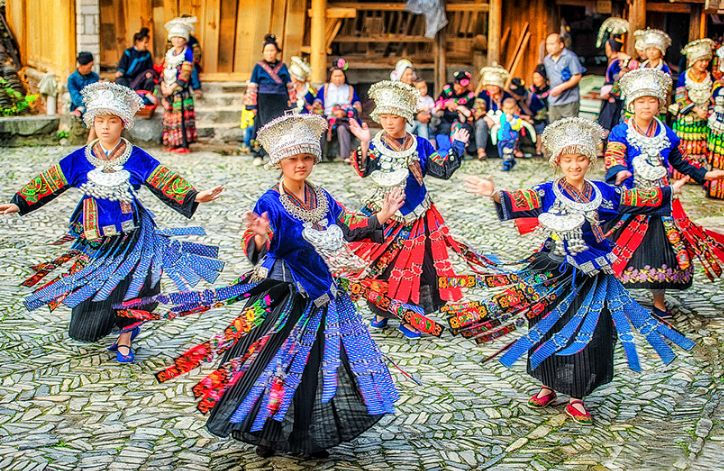 Les femmes miaos dansent en costume traditionnel dans le village Langde au guizhou