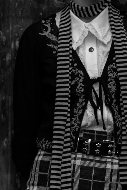 Black and white clothing with intricate embroidered details.