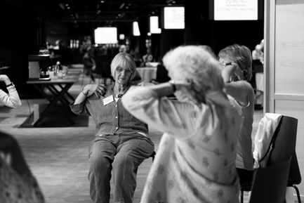 Three people exercising indoors, black and white photo.