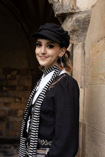 Person smiling, wearing a hat and striped scarf.