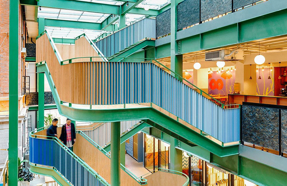 A central metal stairway in a triple height office interior