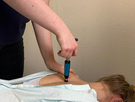 Close-up of a chiropractor using an activator tool on a patient’s spine to deliver a gentle, precise adjustment.