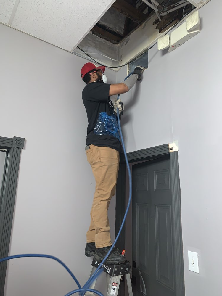 Two Clean Air Pros technicians working in ceiling of German Village Columbus doctor's office — commercial HVAC duct cleaning