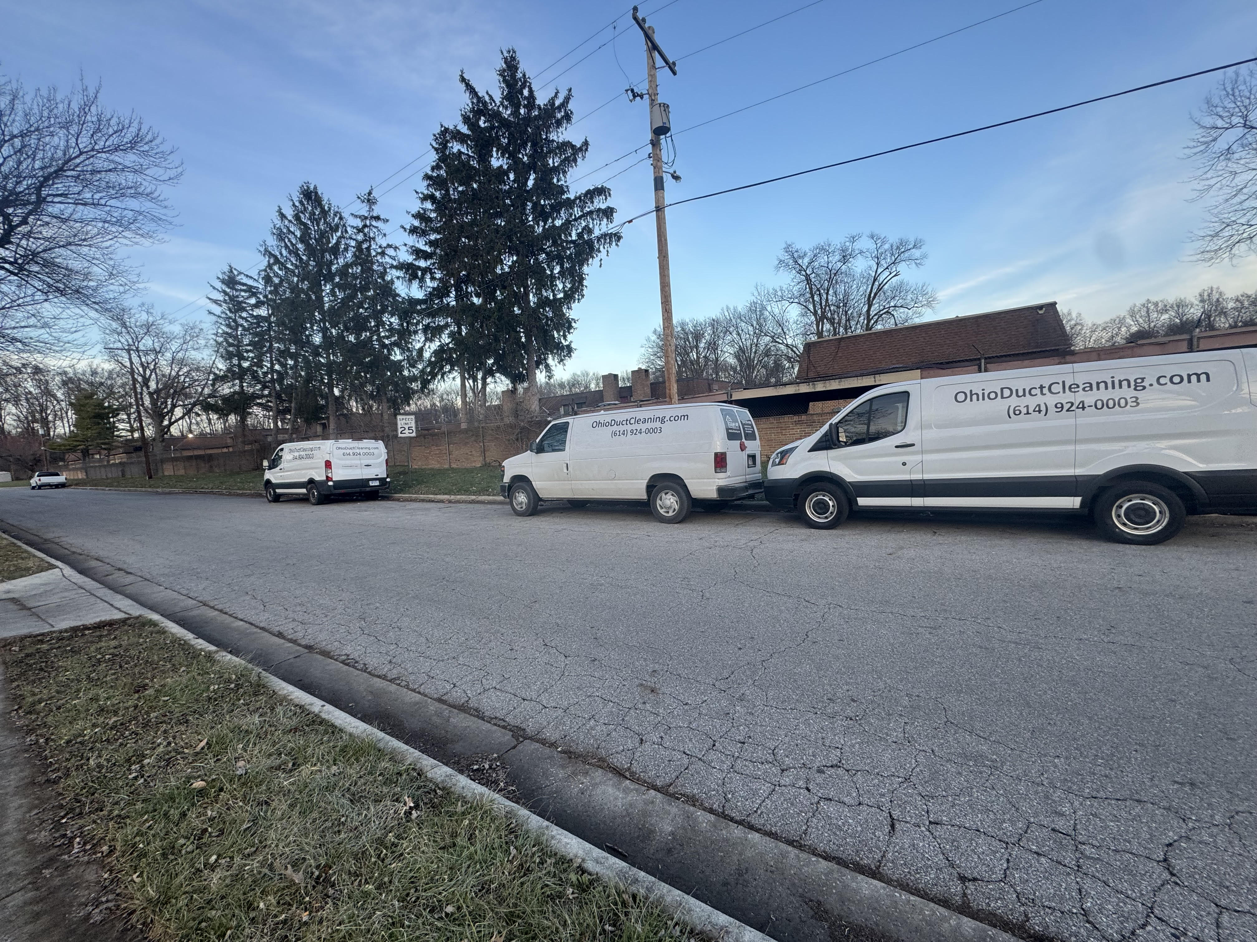 Two Clean Air Pros branded vans at a commercial job site — multi-crew commercial duct cleaning Columbus Ohio