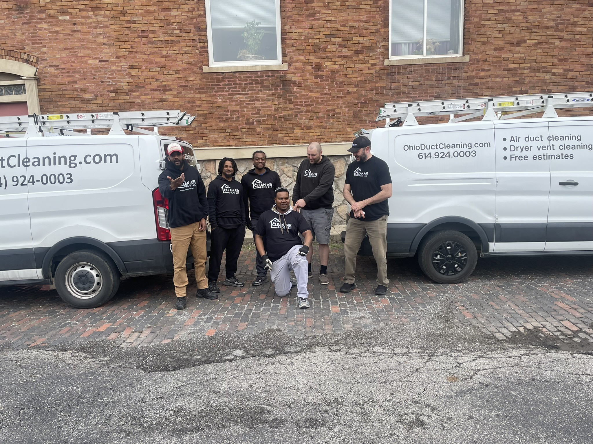 Clean Air Pros full commercial crew between two branded vans after a large Columbus Ohio commercial duct cleaning job